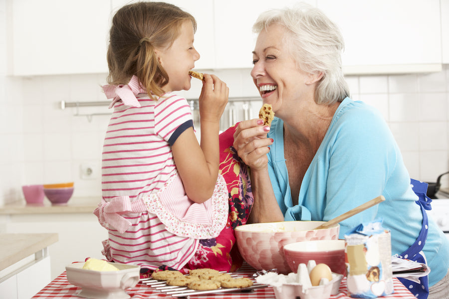 Petite fille et grand-maman, avec chacune un biscuit à la main.
